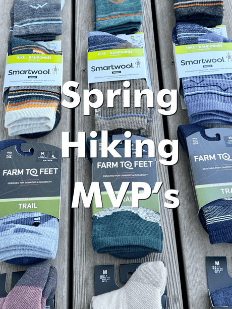 Smartwool hiking socks with packaging on a wooden surface, labeled 'Spring Hiking MVPs'.
